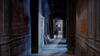 Movie still from “Lisa and the Devil” (1973), directed by Mario Bava – A woman walking down a hall way in a building; Wide shot, High angle