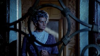 Movie still from “Lisa and the Devil” (1973), directed by Mario Bava – An older woman standing in front of a mirror; Medium shot, Over the shoulder angle