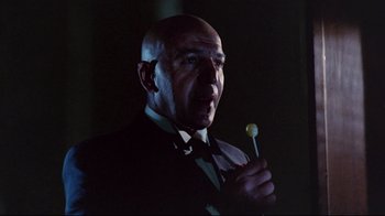 Movie still from “Lisa and the Devil” (1973), directed by Mario Bava – A man in a suit holding a stick in his hand; Close Up shot, Low angle