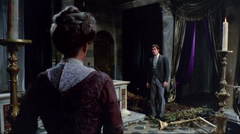 Movie still from “Lisa and the Devil” (1973), directed by Mario Bava – A man and a woman standing in front of a fireplace; Wide shot, Over the shoulder angle