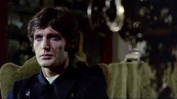 Movie still from “Lisa and the Devil” (1973), directed by Mario Bava – A person sitting in a chair; Close Up shot, Low angle