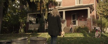 Movie still from “Wish Upon” (2017), directed by John R. Leonetti – A woman and a little girl walking a dog in a yard; Wide shot, Over the shoulder angle