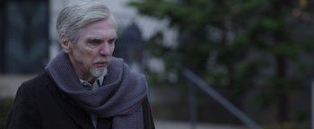 Movie still from “Wish Upon” (2017), directed by John R. Leonetti – An older man with a gray beard wearing a scarf; Close Up shot, Low angle