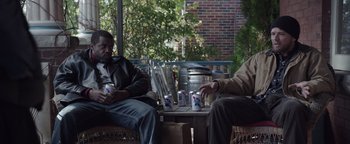 Movie still from “Wish Upon” (2017), directed by John R. Leonetti – Two men are sitting on a porch with cans of beer; Medium shot, High angle