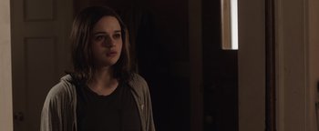 Movie still from “Wish Upon” (2017), directed by John R. Leonetti – A woman standing in a dark room looking at the camera; Close Up shot, Over the shoulder angle