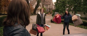 Movie still from “Wish Upon” (2017), directed by John R. Leonetti – A woman holding a bunch of shopping bags in her hands; Medium shot, Over the shoulder angle