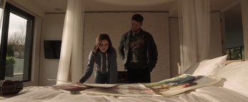 Movie still from “Wish Upon” (2017), directed by John R. Leonetti – A man and a woman looking at books on a table; Medium shot, Over the shoulder angle