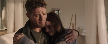 Movie still from “Wish Upon” (2017), directed by John R. Leonetti – A man and a woman hugging in a living room; Close Up shot, Over the shoulder angle