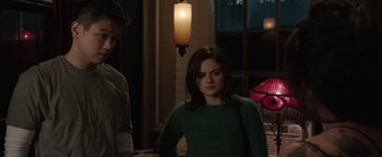 Movie still from “Wish Upon” (2017), directed by John R. Leonetti – A woman in a green sweater standing next to a man in a green sweater; Medium shot, Over the shoulder angle