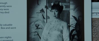 Movie still from “Wish Upon” (2017), directed by John R. Leonetti – An old photo of an asian woman in front of a painting of birds; Close Up shot, Low angle