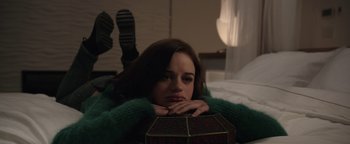 Movie still from “Wish Upon” (2017), directed by John R. Leonetti – A woman laying on the ground with her head resting on her hands; Medium shot, High angle