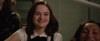 Movie still from “Wish Upon” (2017), directed by John R. Leonetti – A young woman smiling for the camera; Close Up shot, Over the shoulder angle