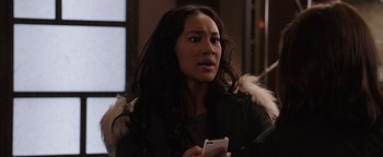 Movie still from “Wish Upon” (2017), directed by John R. Leonetti – A woman holding a cell phone while wearing a jacket; Close Up shot, Over the shoulder angle