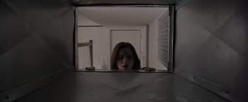 Movie still from “Wish Upon” (2017), directed by John R. Leonetti – A woman is looking through a mirror at the camera; Medium shot, Low angle