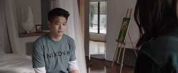 Movie still from “Wish Upon” (2017), directed by John R. Leonetti – A man sitting in front of an easel in a room; Medium shot, Over the shoulder angle