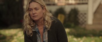 Movie still from “Wish Upon” (2017), directed by John R. Leonetti – A woman with blonde hair and a plaid shirt is standing outside; Close Up shot, Over the shoulder angle