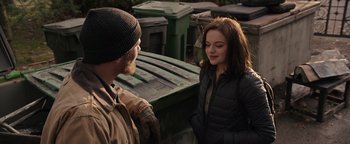 Movie still from “Wish Upon” (2017), directed by John R. Leonetti – A man and a woman standing in front of a trash can; Medium shot, Over the shoulder angle