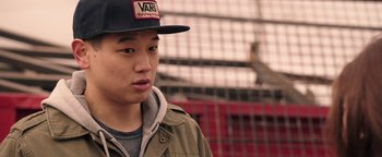 Movie still from “Wish Upon” (2017), directed by John R. Leonetti – A young man wearing a baseball cap and a jacket; Close Up shot, Over the shoulder angle