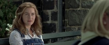 Movie still from “Little Children” (2006), directed by Todd Field – A woman with long brown hair wearing overalls and a white shirt; Close Up shot, Over the shoulder angle