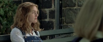 Movie still from “Little Children” (2006), directed by Todd Field – A woman sitting on top of a wooden park bench; Close Up shot, Over the shoulder angle