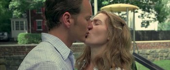Movie still from “Little Children” (2006), directed by Todd Field – A man and a woman kissing each other outside; Close Up shot, Over the shoulder angle