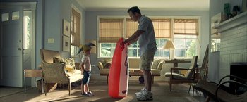 Movie still from “Little Children” (2006), directed by Todd Field – A man and a child standing in a living room; Medium shot, High angle