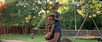 Movie still from “Little Children” (2006), directed by Todd Field – A man and a boy are playing in the yard; Medium shot, Low angle