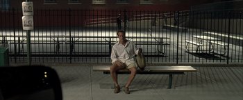 Movie still from “Little Children” (2006), directed by Todd Field – A man sitting on top of a wooden park bench; Wide shot, High angle