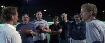 Movie still from “Little Children” (2006), directed by Todd Field – A group of men standing next to each other on top of a tennis court; Medium shot, Low angle