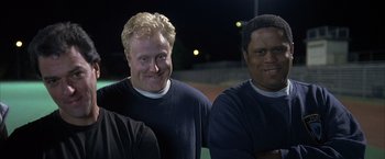 Movie still from “Little Children” (2006), directed by Todd Field – A group of men standing next to each other on top of a baseball field; Close Up shot, Low angle