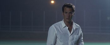 Movie still from “Little Children” (2006), directed by Todd Field – A man in a white shirt is standing in the dark; Close Up shot, Low angle