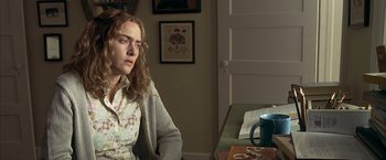 Movie still from “Little Children” (2006), directed by Todd Field – A woman sitting at a table with a cup of coffee in front of her; Medium shot, High angle