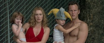 Movie still from “Little Children” (2006), directed by Todd Field – A man and a woman and a boy wearing a banana hat; Close Up shot, Over the shoulder angle