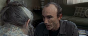 Movie still from “Little Children” (2006), directed by Todd Field – A man is talking to another man in a room; Close Up shot, Over the shoulder angle