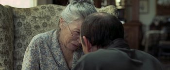 Movie still from “Little Children” (2006), directed by Todd Field – An older woman sitting next to a younger man on a couch; Close Up shot, Over the shoulder angle