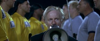 Movie still from “Little Children” (2006), directed by Todd Field – A man with blonde hair is holding a megaphone; Close Up shot, Low angle