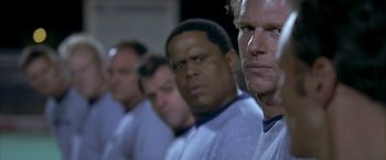 Movie still from “Little Children” (2006), directed by Todd Field – A group of men standing next to each other in a row; Close Up shot, Low angle