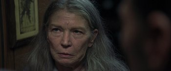 Movie still from “Little Children” (2006), directed by Todd Field – An older woman with long gray hair looking at the camera; Close Up shot, Over the shoulder angle