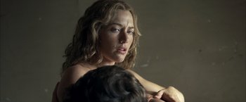 Movie still from “Little Children” (2006), directed by Todd Field – A person holding a child in a room; Close Up shot, Over the shoulder angle