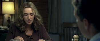 Movie still from “Little Children” (2006), directed by Todd Field – A woman sitting at a table looking down at her cell phone; Close Up shot, Over the shoulder angle