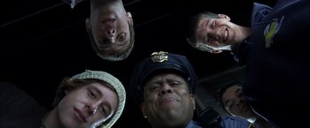 Movie still from “Little Children” (2006), directed by Todd Field – A group of men in hats and a police officer; Close Up shot, Low angle