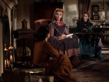 Movie still from “Little Women” (1949), directed by Mervyn LeRoy – Two women and a man sitting in a living room; Wide shot, High angle