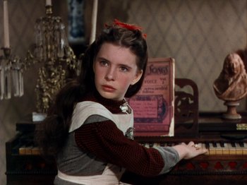 Movie still from “Little Women” (1949), directed by Mervyn LeRoy – A young girl sitting at a piano in a room; Close Up shot, High angle
