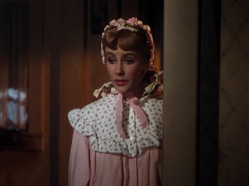 Movie still from “Little Women” (1949), directed by Mervyn LeRoy – A woman dressed as a little girl in a pink dress; Close Up shot, Over the shoulder angle