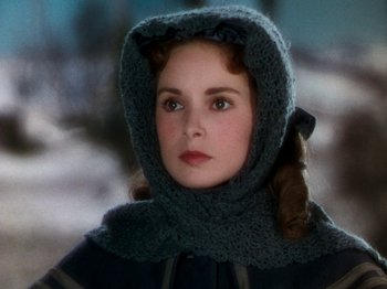Movie still from “Little Women” (1949), directed by Mervyn LeRoy – A young woman wearing a hooded scarf and a cape; Close Up shot, Over the shoulder angle