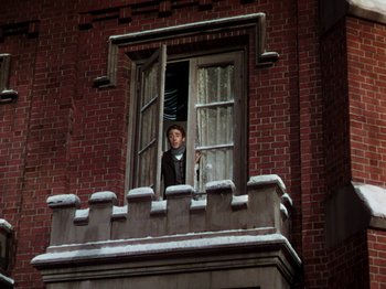 Movie still from “Little Women” (1949), directed by Mervyn LeRoy – A man looking out of a window on a brick building; Wide shot, Low angle