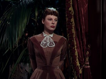 Movie still from “Little Women” (1949), directed by Mervyn LeRoy – A woman in a brown dress with a heart necklace; Medium shot, Low angle