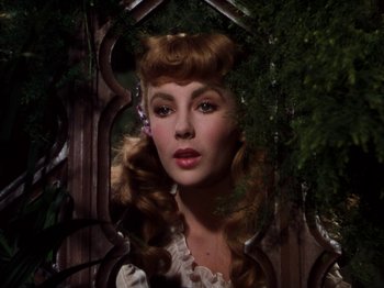 Movie still from “Little Women” (1949), directed by Mervyn LeRoy – A woman in a white dress with a flower in her hair; Close Up shot, Over the shoulder angle