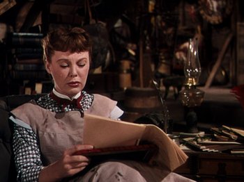 Movie still from “Little Women” (1949), directed by Mervyn LeRoy – A woman sitting in a chair reading a book; Medium shot, Low angle