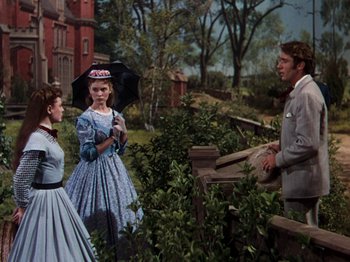 Movie still from “Little Women” (1949), directed by Mervyn LeRoy – Two women and a man stand in front of a fence; Medium shot, Over the shoulder angle